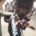 Boy accessing clean water from tap